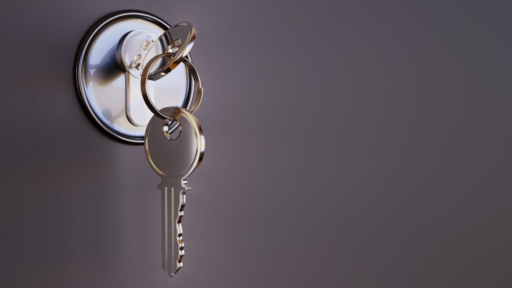 Schlüssel in silbernem Schloss mit zweitem Schlüssel, der am Schlüsselring herunterhängt