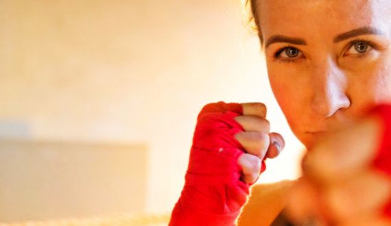 boxende Frau mit roten Bandagen an den Händen